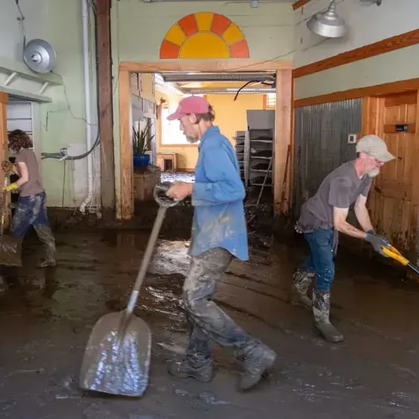Mud left by floodwater being shoveled out of a building during cleanup