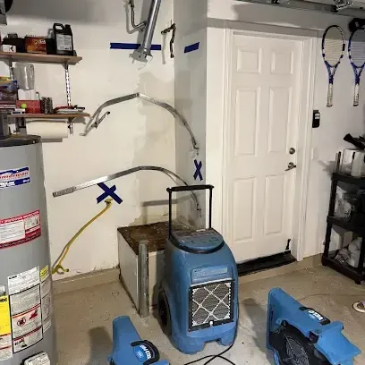 Drying equipment arranged around a water heater in a garage