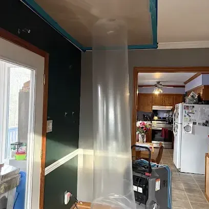 A plastic containment column and a dehumidifier set up in a home during a water damage dry-out