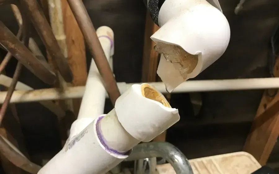 A PVC line split open by a hard freeze under a raised floor